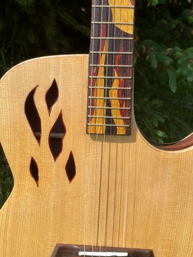 Acoustic guitar with flame inlays on the fretboard